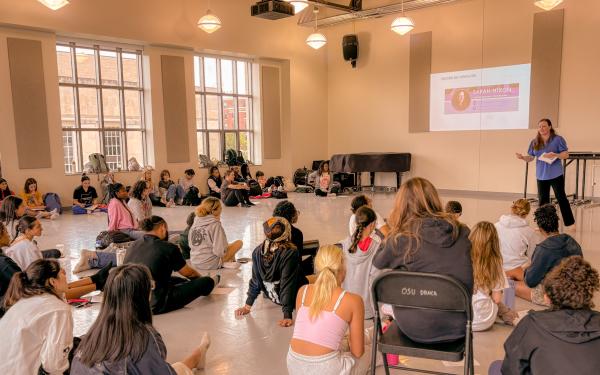 Sara Hixon gives a presentation in front of a large group of college students