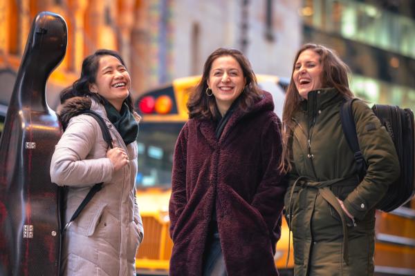 The members of Trio Phos laughing on the street.