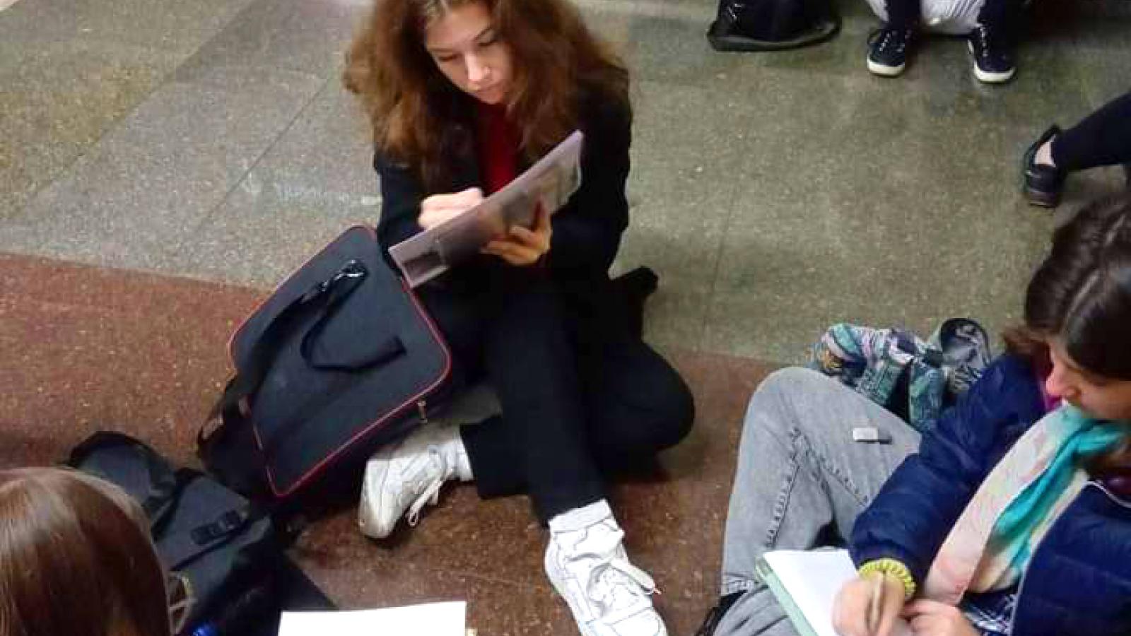 Students sketching while sheltering in the subway